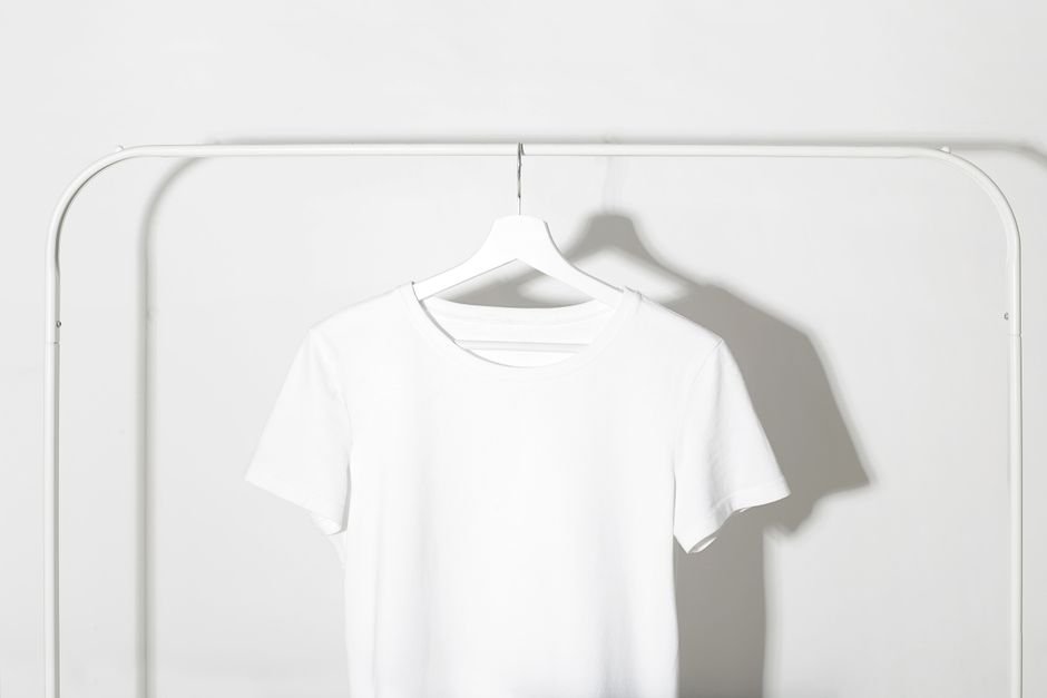 Flat lay of affordable mom wardrobe staples including neutral tees, jeans, and versatile shoes — essential pieces for daily styling