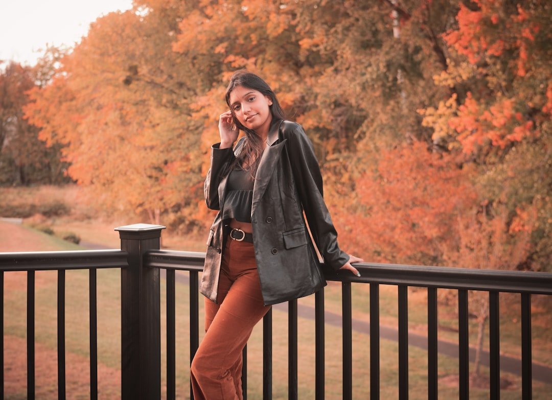 Layered trench coat, turtleneck, and skirt styled as a transitional fall outfit.