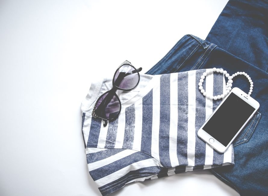 Capsule wardrobe essentials for cute summer outfits including denim shorts, tanks, midi skirt, and cardigan