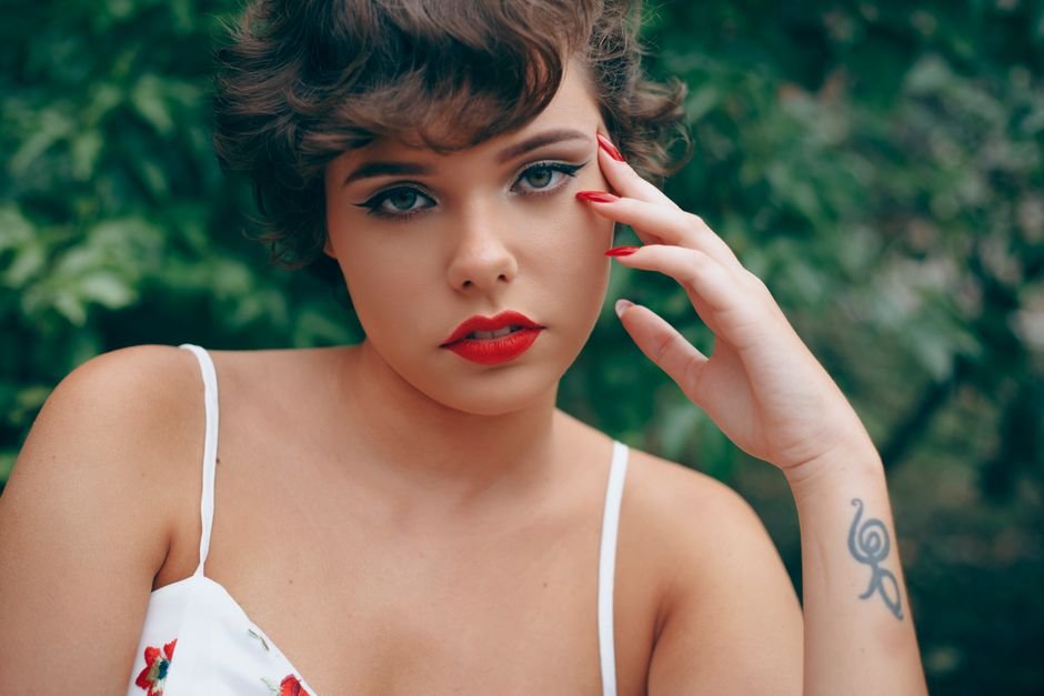 Celebrity-inspired short nail looks including glazed donut trend, nude shades, and classic red manicures