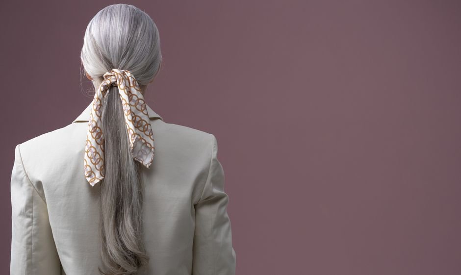 Small silk scarf and twilly styled on handbag, wrist, and layered with jewelry