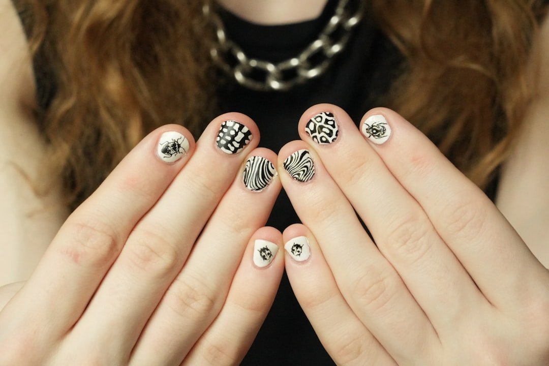 DIY October nails with burnt orange polish and hand-painted leaf designs using simple at-home techniques.