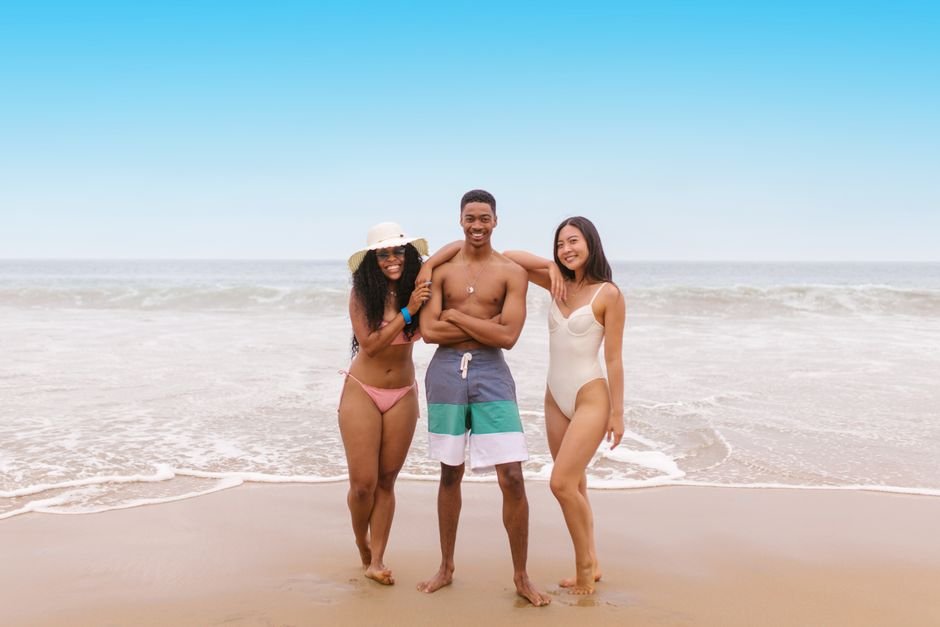 Essential beach wardrobe pieces including swimsuits, cover-ups, hats, and straw bags styled for chic seaside fashion