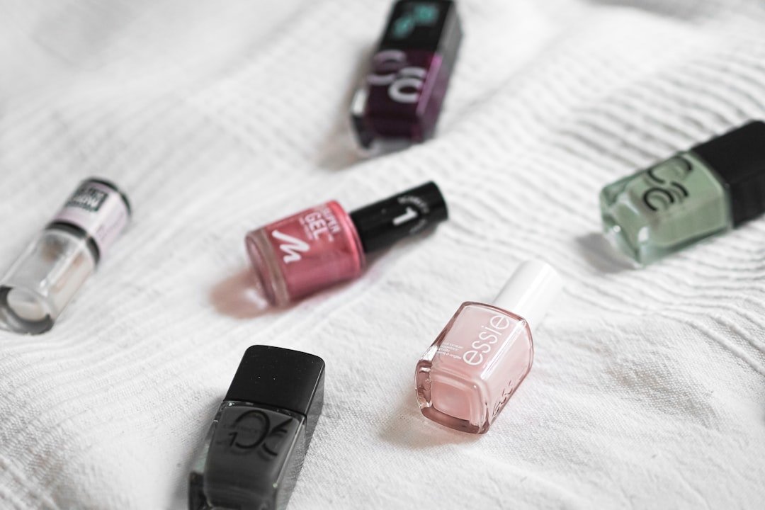 Fall nails color palette featuring burgundy, burnt orange, brown, and green nail swatches displayed against autumn leaves