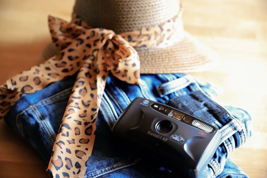 Woman in leopard print maxi dress with sunglasses and woven tote bag styled for a chic summer day outfit