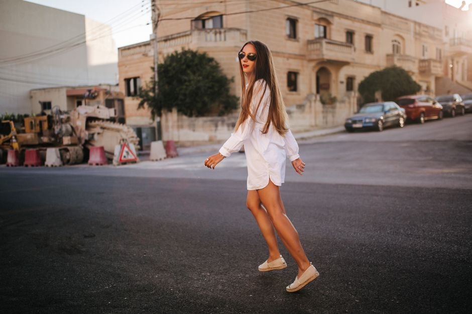 Summer footwear including sandals, wedges, sneakers, and espadrilles styled with white summer dresses.