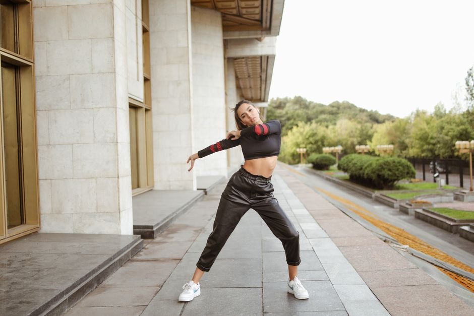 Woman in a summer outfit featuring a cropped blouse and high-waisted trousers in an urban setting