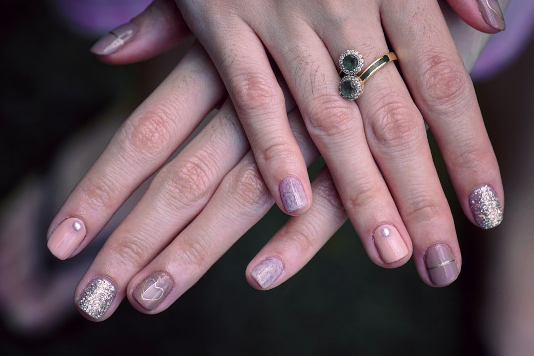 Almond shape fall nails in jewel tones emerald green, sapphire blue, and amethyst purple with gold rings