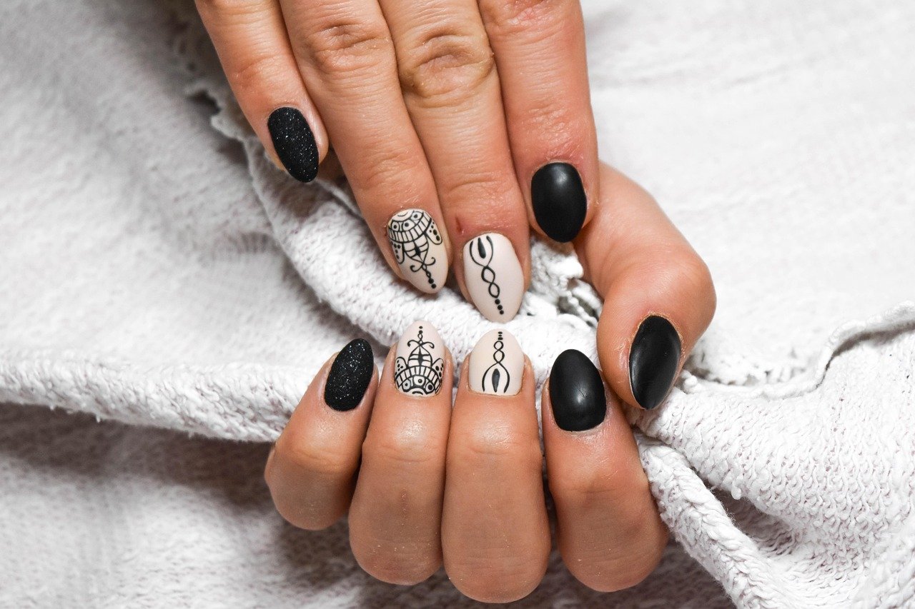 Burnt orange manicure with nail care essentials like cuticle oil, gloves, and top coat for long-lasting nails