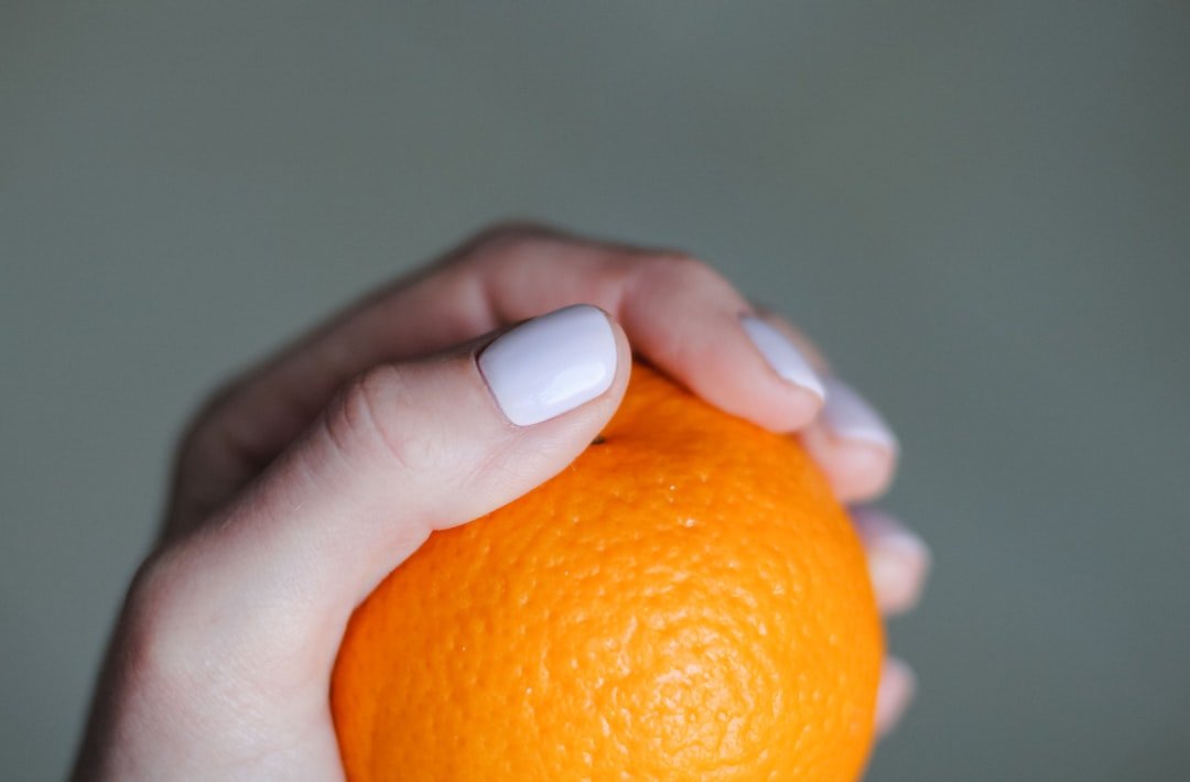 Variety of orange nail polish shades and manicure tools showing the 2025 nail color trend