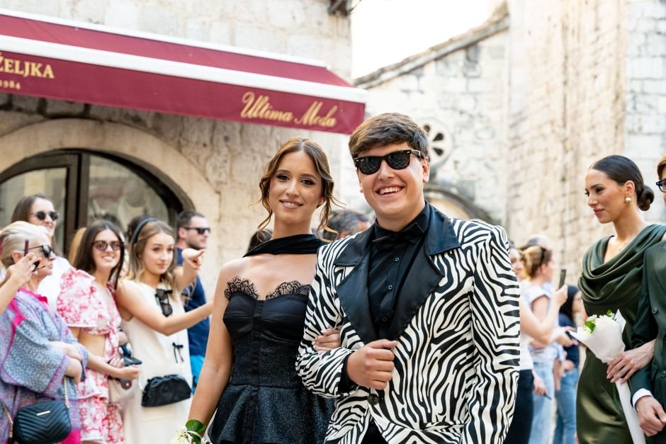 Light fabrics and vibrant prints for summer wedding guest outfits laid out with accessories.