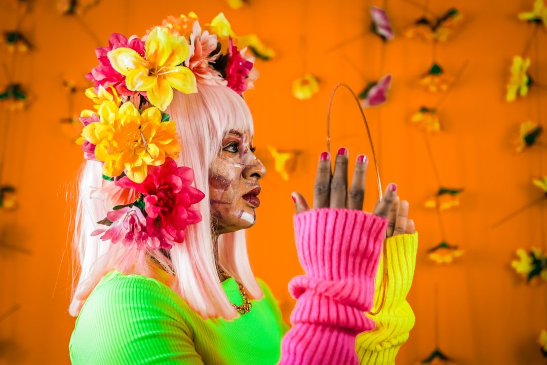 Neon orange nails with glow-in-the-dark effects and rhinestone accents styled for festival season