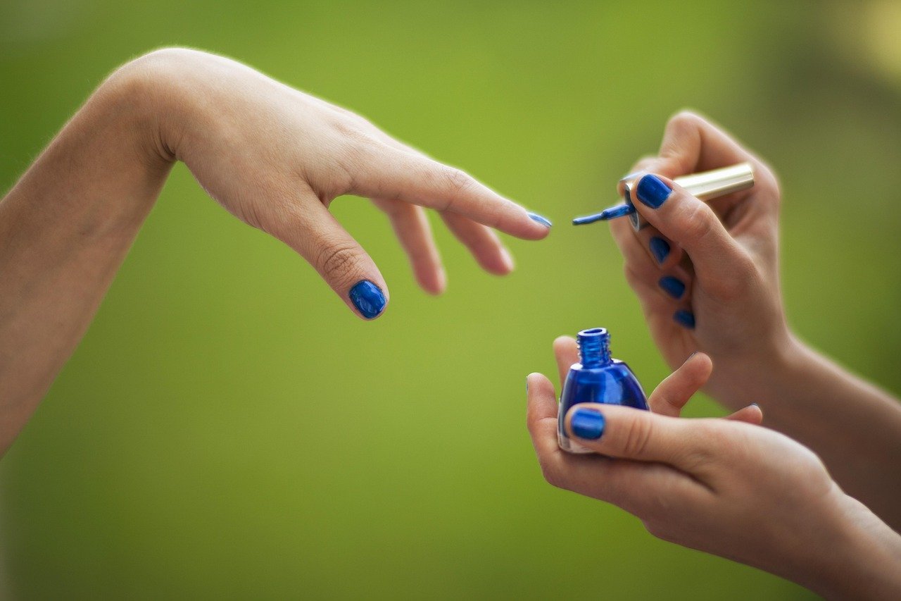 Professional brown and blue nails with matte navy base and subtle brown French tips styled in workplace setting