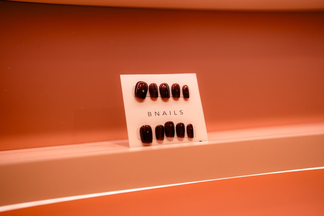 Professional October nails with deep wine polish and gold foil accents for an elegant fall manicure.