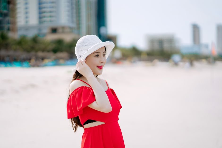 Different beach outfit ideas styled for activities: elegant caftan for beach club, sporty bikini with shorts, and casual maxi dress