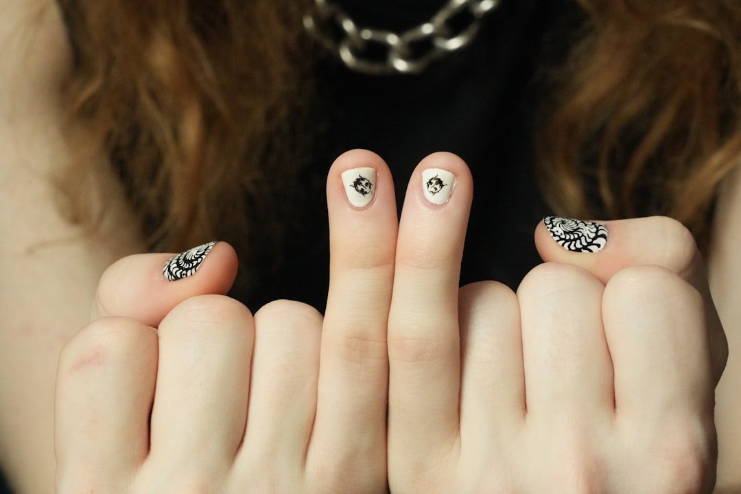 Hand with mixed swirl nail designs including retro swirls, holographic finishes, and metallic accents