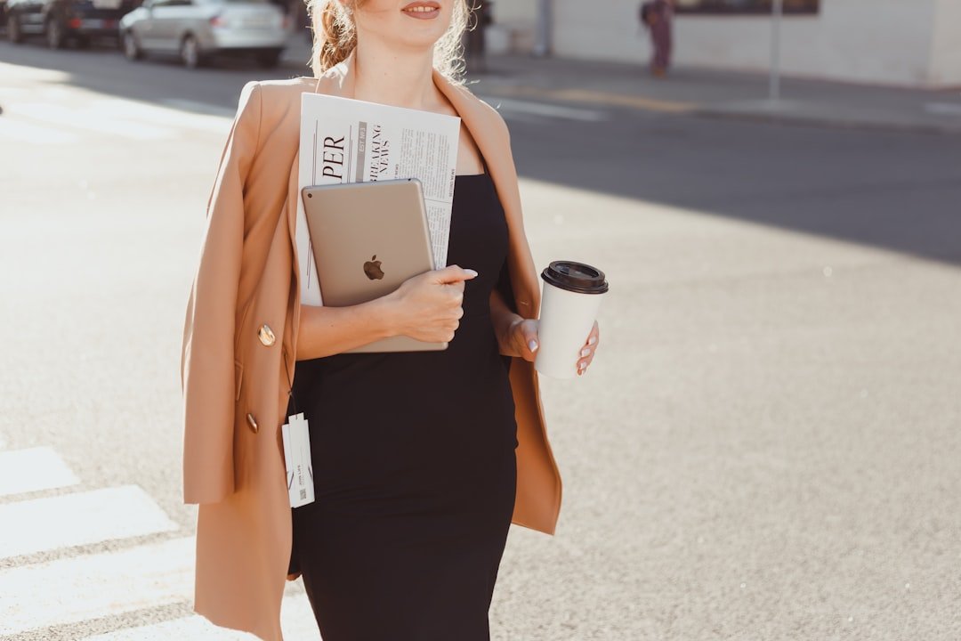 A professional early fall outfit featuring tailored trousers, a silk blouse, and a plaid blazer, demonstrating how to seamlessly transition work outfits for early fall weather.
